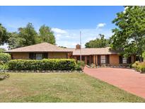 Charming brick home with a well-manicured lawn, mature trees, and a red brick driveway at 6157 Ne 25Th Ave, Ocala, FL 34479
