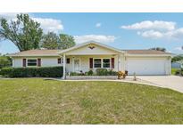 Charming single-story home featuring a well-maintained lawn, classic design, and attached two car garage at 6448 Sw 111Th Pl, Ocala, FL 34476