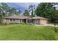 Charming single-story home boasts lush lawn, screened entry, and attached garage at 14330 Sw 79Th Ter, Ocala, FL 34473