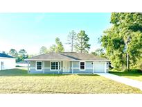 Charming single-story home with a manicured lawn and attached one car garage at 14415 Sw 21St Pl, Ocala, FL 34481
