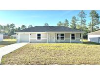Charming single-story home featuring a well-manicured lawn, attached garage, and neutral exterior paint at 14425 Sw 21St Pl, Ocala, FL 34481