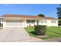 Charming single-story home featuring a well-maintained front yard and attached two-car garage at 17574 Se 95Th Ct, Summerfield, FL 34491