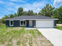 Charming single-story home featuring a well-maintained lawn and a spacious two-car garage at 22777 Sw Beach Blvd, Dunnellon, FL 34431