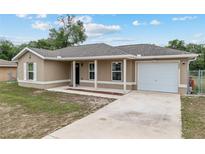 Charming single-story home featuring a cozy porch, neutral-toned exterior, and attached one-car garage at 2690 Sw 154Th Ln, Ocala, FL 34473