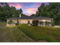 Charming single story home featuring a well manicured lawn, mature trees, and neutral color palette at 3880 Sw 6Th Ave, Ocala, FL 34471