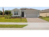 Charming single-story home featuring a neutral color palette, well-manicured lawn, and a brick-paved driveway at 4892 Nw 39Th Loop, Ocala, FL 34482