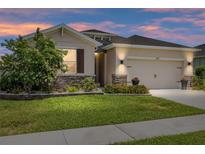 Charming single-story home with a well-manicured lawn, stone accents, and a two-car garage at 6265 Sw 88Th Loop, Ocala, FL 34476