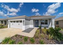 Charming single-story home with a well-manicured lawn, a two car garage, and a decorative glass front door at 7987 Sw 89Th Cir, Ocala, FL 34481