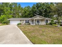 Charming single-story home featuring a welcoming front porch and well-maintained landscaping at 8137 Sw 117Th Loop, Ocala, FL 34481