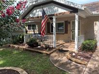 Charming front porch with American flag, white railings, and brick accents creates inviting curb appeal at 9801 Sw 88Th Ter # B, Ocala, FL 34481
