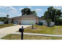 Charming single-story home features a two-car garage, manicured lawn, and inviting entryway at 1129 Wilmington Dr, Deltona, FL 32725