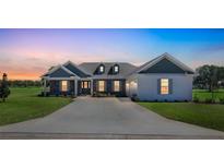 Beautiful single-story home featuring a stone facade, dormer windows, and a well-manicured front lawn at 2050 Nw 79Th Loop, Ocala, FL 34475