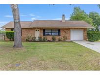 Charming brick home with a well-manicured lawn and attached one-car garage at 2819 Ne 32Nd Pl, Ocala, FL 34479