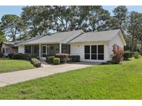 Charming single-story home with a well-manicured lawn and a screened in porch at 36 Gordon Ct, Leesburg, FL 34788