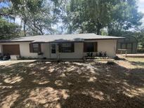 Charming single story home featuring a neutral exterior, shuttered windows, and mature shade trees at 3800 Ne 24Th Ct, Ocala, FL 34479