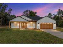 Charming single-story home with a well-manicured lawn, brown garage door and inviting covered porch at 8200 Sw 125Th Court Rd, Dunnellon, FL 34432