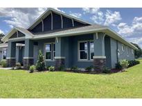 Beautiful exterior of a modern home featuring manicured lawn and stylish stone accents on the columns at 8290 Nw 17Th Cir, Ocala, FL 34475