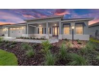 Beautiful single-story home featuring a well-manicured lawn, elegant landscaping, and a covered front entry at 8465 Sw 101St Ave, Ocala, FL 34481