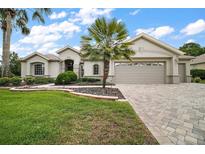 Beautiful single-story home features a manicured lawn, mature landscaping, and a neutral color palette at 9459 Se 124Th Loop, Summerfield, FL 34491