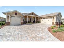 Charming single-story home featuring a brick paved driveway and two-car garage in a well manicured yard at 9607 Sw 79Th Lane Rd, Ocala, FL 34481