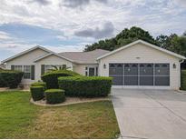 Charming single-story home with a well-manicured lawn and a two-car garage, enhanced by lush landscaping at 13863 Se 85Th Cir, Summerfield, FL 34491