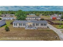 Well-maintained home featuring black shutters, neutral siding, and an inviting front porch at 14276 Se 61St Ave, Summerfield, FL 34491