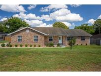Charming single-story brick home with a well-manicured lawn and blue skies at 3295 Se 56 Ave, Ocala, FL 34480