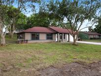 Charming single-story home featuring a well-maintained lawn and mature trees at 346 Emerald Rd, Ocala, FL 34472