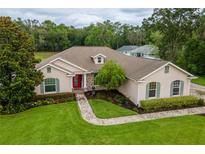 Charming home featuring well-manicured landscaping, brick walkway, and a welcoming red front door at 4015 Se 22Nd St, Ocala, FL 34471