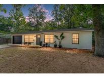 Charming single-story home featuring a manicured lawn and a welcoming front porch with stylish front door and attached garage at 4601 Se 18Th Ave, Ocala, FL 34480