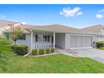 Charming single-story home featuring a covered porch, well-manicured lawn, and attached garage at 8885 Sw 90Th Ave, Ocala, FL 34481