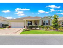 Charming single-story home with a well-manicured lawn, beautiful landscaping, and an attached two-car garage at 9203 Sw 97Th Cir, Ocala, FL 34481