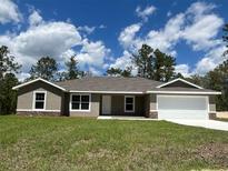 Charming single-story home with neutral paint, stone accents, and a well-manicured lawn at 12505 Sw 73Rd St, Ocala, FL 34481