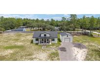 Charming home featuring a covered porch, spacious yard, and a detached garage at 13663 Sw 66Th St, Ocala, FL 34481