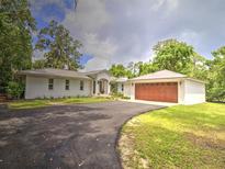 Charming single-story home with a metal roof, attached garage and well-manicured lawn at 1610 Se 22Nd Ave, Ocala, FL 34471