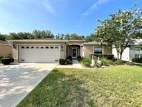 Charming single-story home featuring a two-car garage and well-manicured lawn with a decorative pelican statue at 16405 Sw 14Th Avenue Rd, Ocala, FL 34473