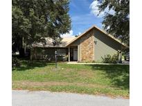 Charming home featuring a stone facade, metal roof and well-maintained lawn at 22 Pine Circle Way, Ocala, FL 34472