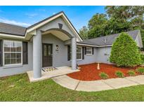 Inviting front entrance with fresh mulch, mature landscaping, and a covered porch at 380 Ne 53Rd St, Ocala, FL 34479