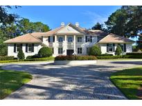 Stately home with manicured front lawn, circular driveway, and elegant architectural details at 4026 Nw 85Th Ter, Ocala, FL 34482