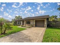 Charming single-story home featuring a well-maintained lawn, stone accents and an attached two-car garage at 5720 Se 20Th St, Ocala, FL 34480