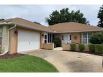 Charming single-story home featuring an attached garage, manicured landscaping, and a welcoming front entrance at 7251 Sw 115Th Pl, Ocala, FL 34476