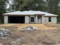 Single-story home under construction featuring block construction, attached garage, and a simple, modern design in a natural setting at 7568 Sw 204Th Ave, Dunnellon, FL 34431