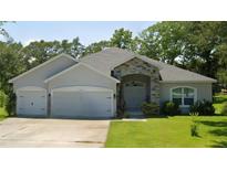 Charming single-story home with a well-manicured lawn and a welcoming stone entryway at 11412 Sw 51St Cir, Ocala, FL 34476