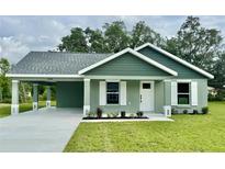 Charming single-story home with a well-maintained lawn and covered carport, showcasing curb appeal at 13319 Sw 106Th Pl, Dunnellon, FL 34432