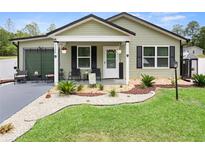 Charming single-story home featuring a covered porch, well-manicured lawn, and inviting curb appeal at 15324 Sw 40Th Place Rd, Ocala, FL 34481