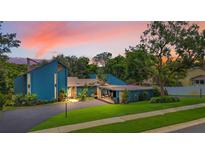 Charming two-story blue home with mature landscaping, covered parking and a spacious driveway at 2922 Cocovia Way, Leesburg, FL 34748