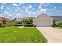 Charming single-story home with a well-manicured lawn and attached two-car garage at 3024 Burbank Ln, The Villages, FL 32162