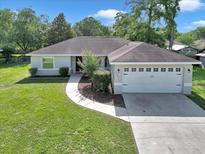 Charming home featuring a well-maintained lawn and an attached two-car garage at 4085 Ne 17Th Ave, Ocala, FL 34479