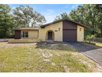 Charming one-story home featuring a stucco exterior, arched entryway, and a one-car garage at 4467 Sw Channel Heights Ct, Dunnellon, FL 34431