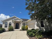 Well maintained one story home featuring a low-pitched roof, arched windows, and a manicured lawn at 4940 Sw 63Rd Loop, Ocala, FL 34474